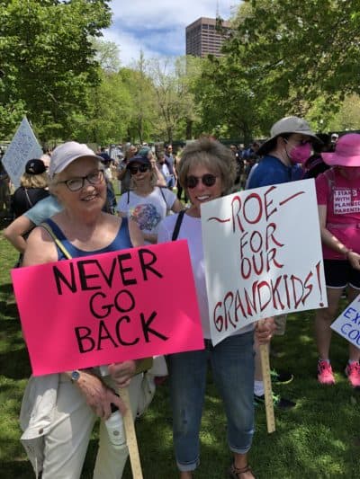 Linda Whittlesey (left), of Cape Cod, and Betsy Edwards (right), of Jamaica Plain, hold signs at the Boston Common abortion rights protest. (Barbara Moran/WBUR)