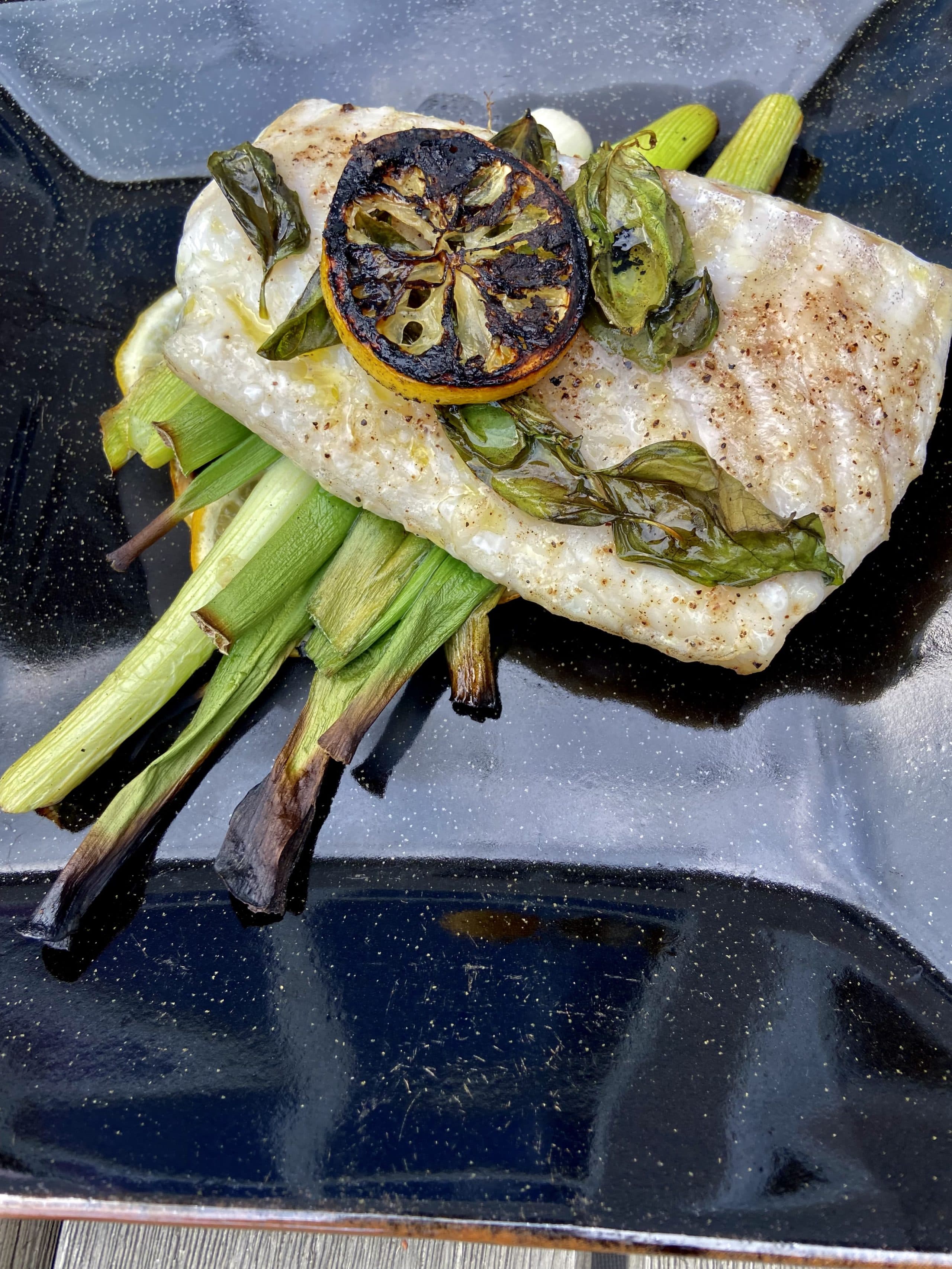 Grilled cod with basil on a lemon and scallion 'bed' (Kathy Gunst/Here &amp; Now)