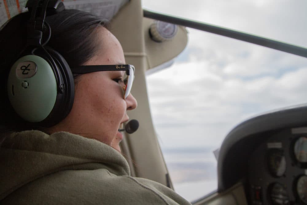 Dolena Fox flying a silver and blue-striped Cessna 207 to the village of Tuntutuliak. (Olivia Ebertz/KYUK)
