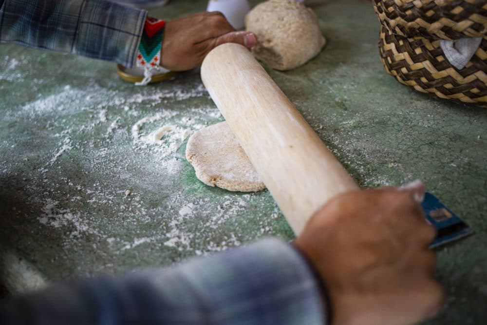 Lucia Gomez flattens out dough for simple flat breads. (Murphy Woodhouse/KJZZ)