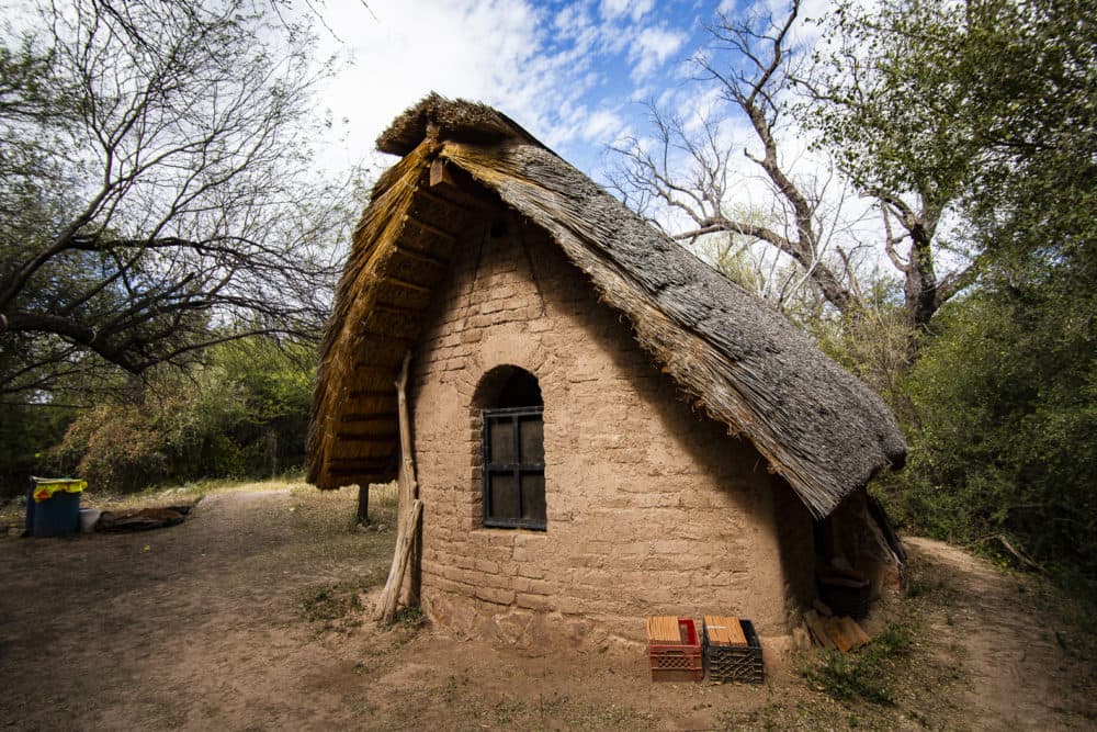 An adobe, thatched roof structure on the property will eventually be a studio space, but has taken far longer than anticipated to finish. (Murphy Woodhouse/KJZZ)