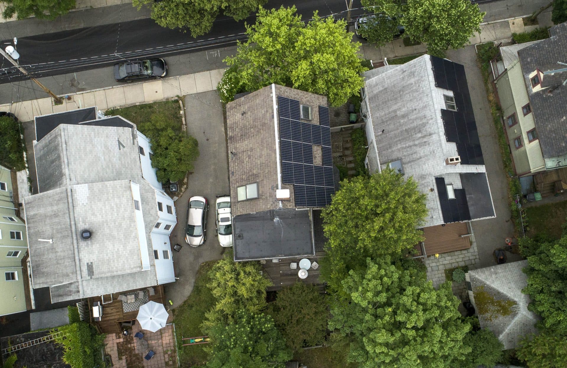 Jurgen Weiss' home, surrounded by trees on a small Somerville lot, leaves little space for a geothermal well, and little access to drill one. (Robin Lubbock/WBUR)