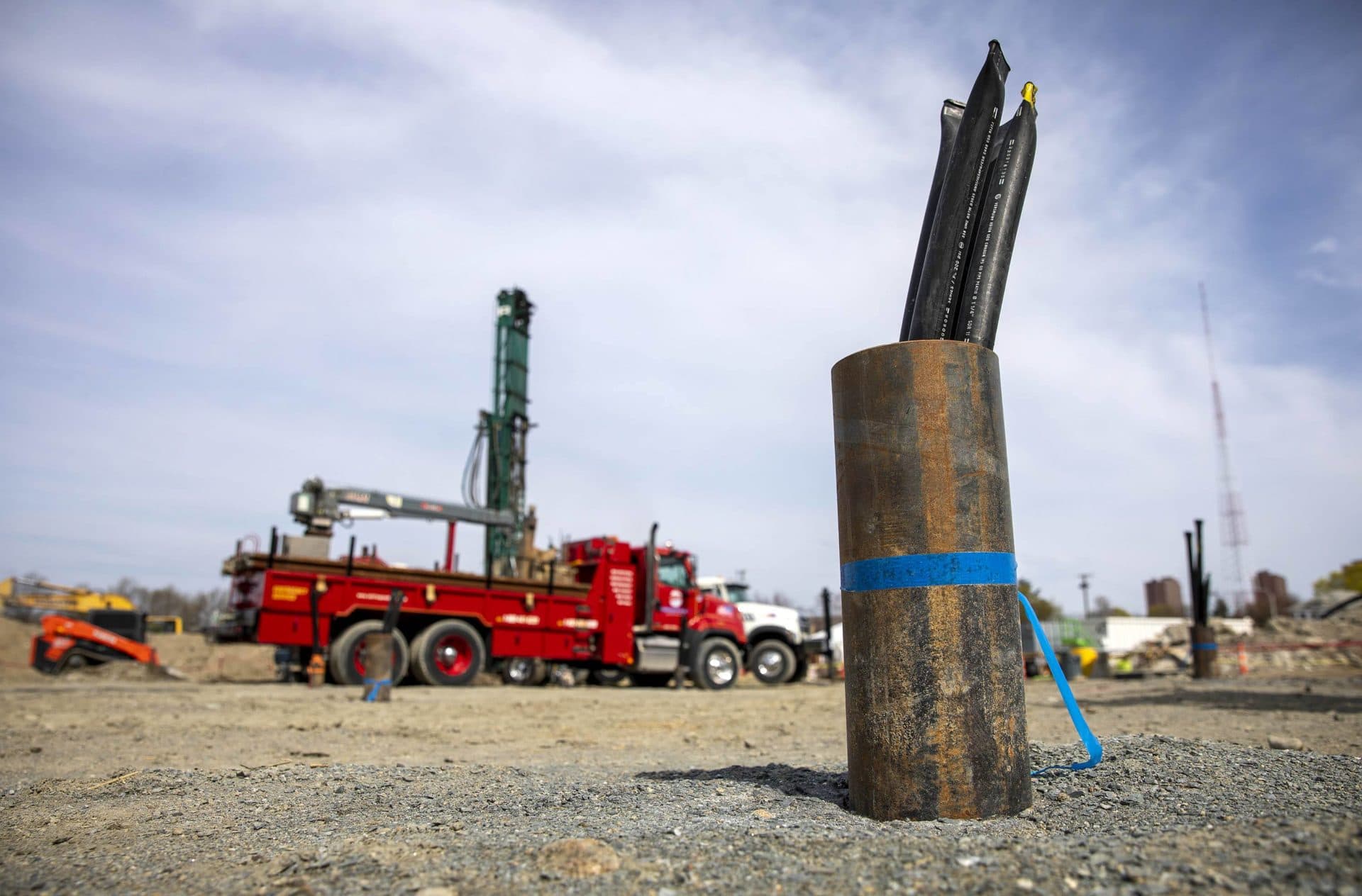 A vertical geothermal metal tube sticks out of the ground in Cambridge, carrying two geothermal pipes connected at the bottom of the well with a U-bend to form a loop. (Robin Lubbock/WBUR)