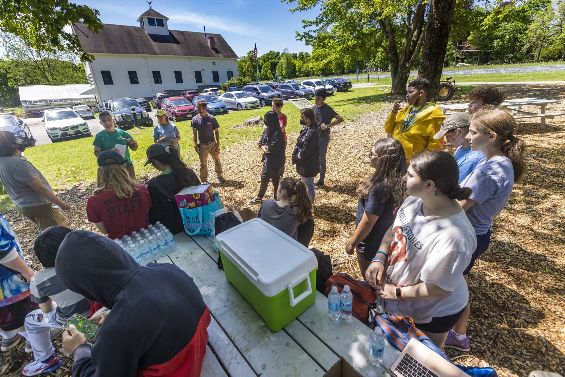 Community Harvest Volunteer Manager Wayne McAuliffe huddles with the students from Worcester's South High School after the work in the morning has been done. They have planted 2,784 plants. (Jesse Costa/WBUR)