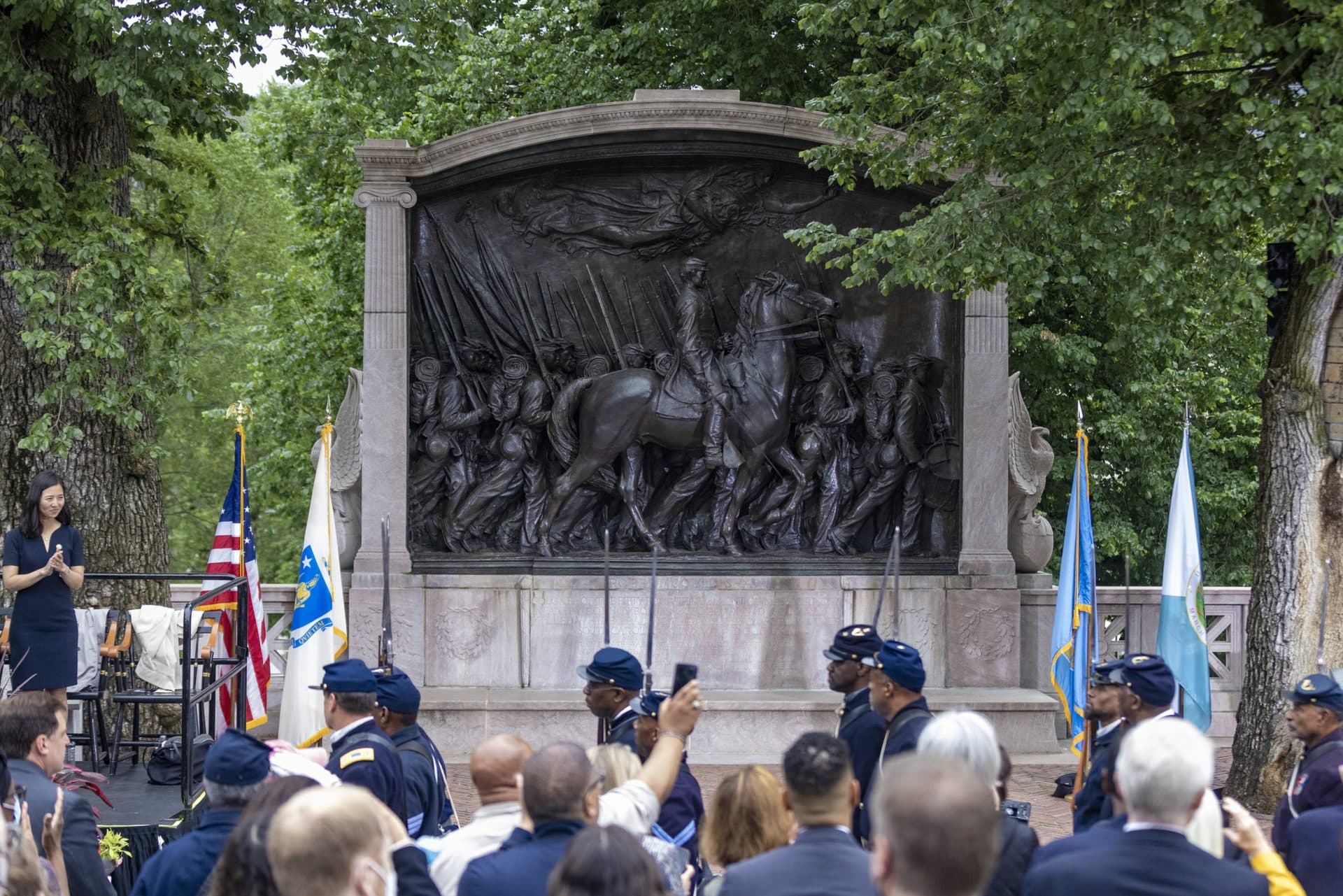 Members of the audience watch as the 54th Massachusetts Volunteer Regiment march past the Robert Gould Shaw and the 54th Regiment Memorial. (Jesse Costa/WBUR)