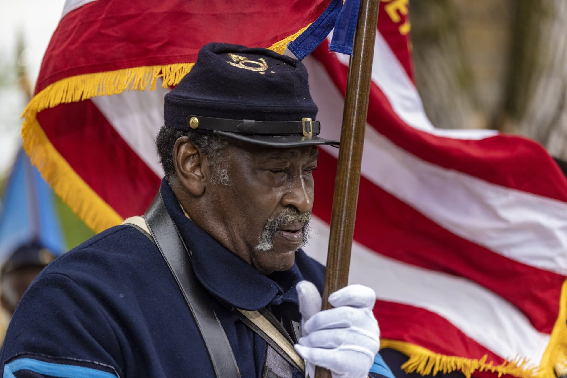 Quartermaster Reggie Dumas of the 54th Massachusetts Volunteer Regiment holds the American flag during the Robert Gould Shaw and the 54th Regiment Memorial rededication ceremony. (Jesse Costa/WBUR)