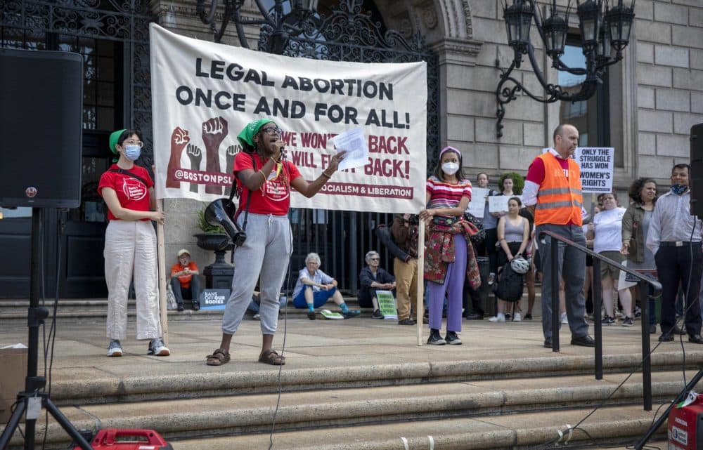 Party for Socialism and Liberation organizer Gabby Ballard talks to abortion-rights protesters from the steps of the Boston Public Library in Copley Square. (Robin Lubbock/WBUR)