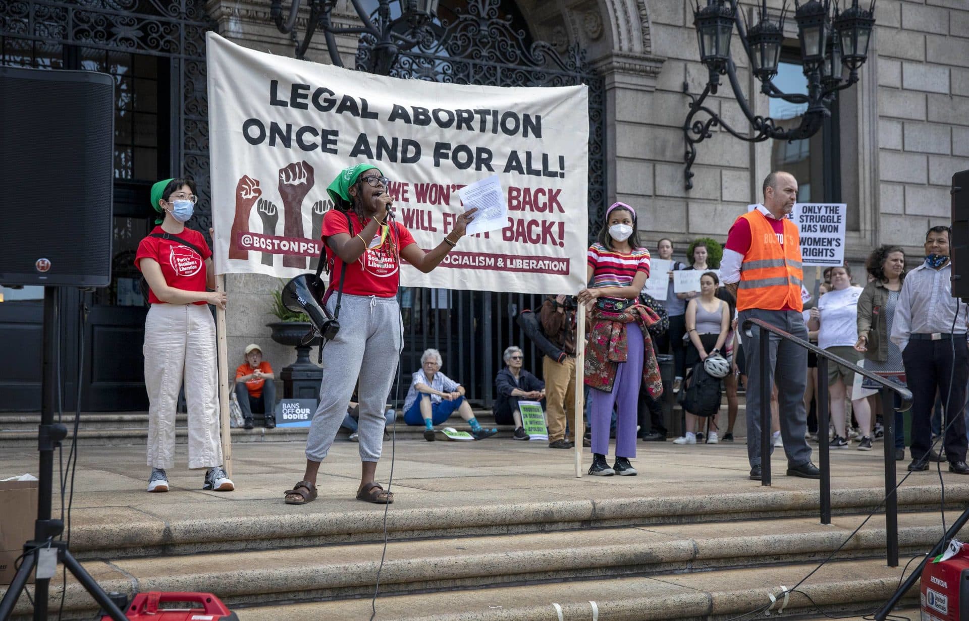Party for Socialism and Liberation organizer Gabby Ballard talks to abortion-rights protesters from the steps of the Boston Public Library in Copley Square. (Robin Lubbock/WBUR)
