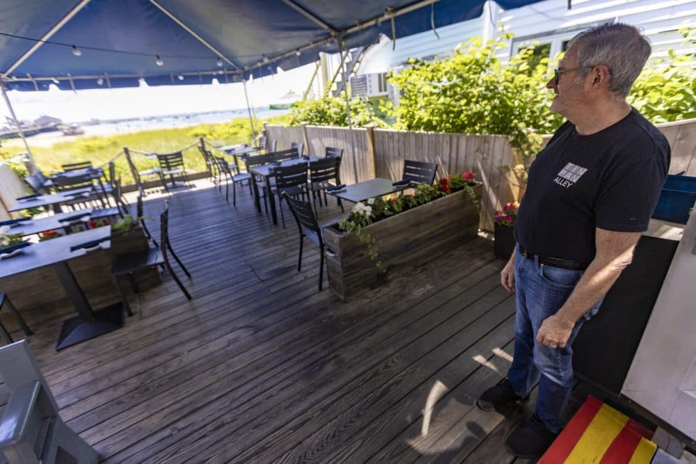 Paul Melanson, co-owner of The Tin Pan Alley Restaurant, stands out on the deck, which was covered with a tent during the pandemic to maximize business. (Jesse Costa/WBUR)