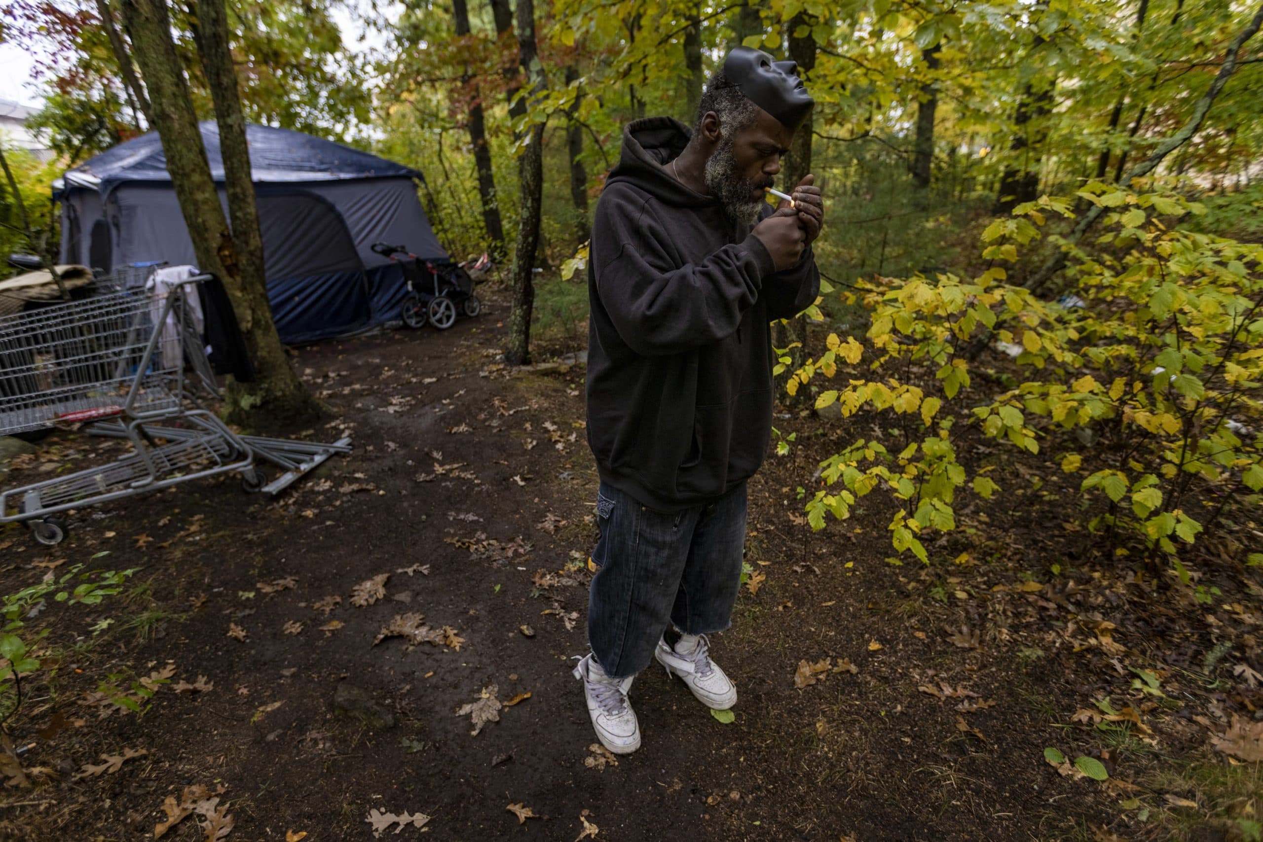Dave outside his tent, lighting a cigarette. (Jesse Costa/WBUR)