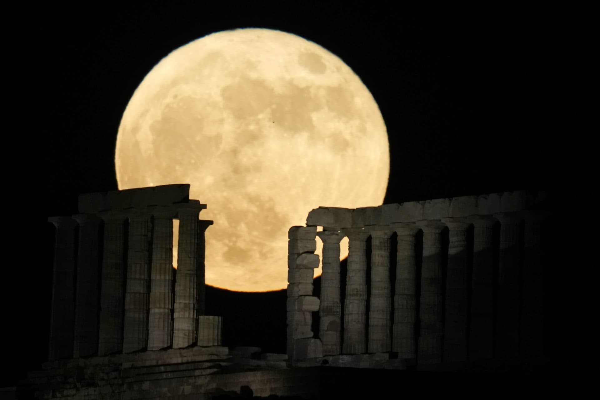 The strawberry full moon rises behind the ancient temple of Poseidon at Cape Sounion, about 45 miles south of Athens, Greece. (Thanassis Stavrakis/AP)
