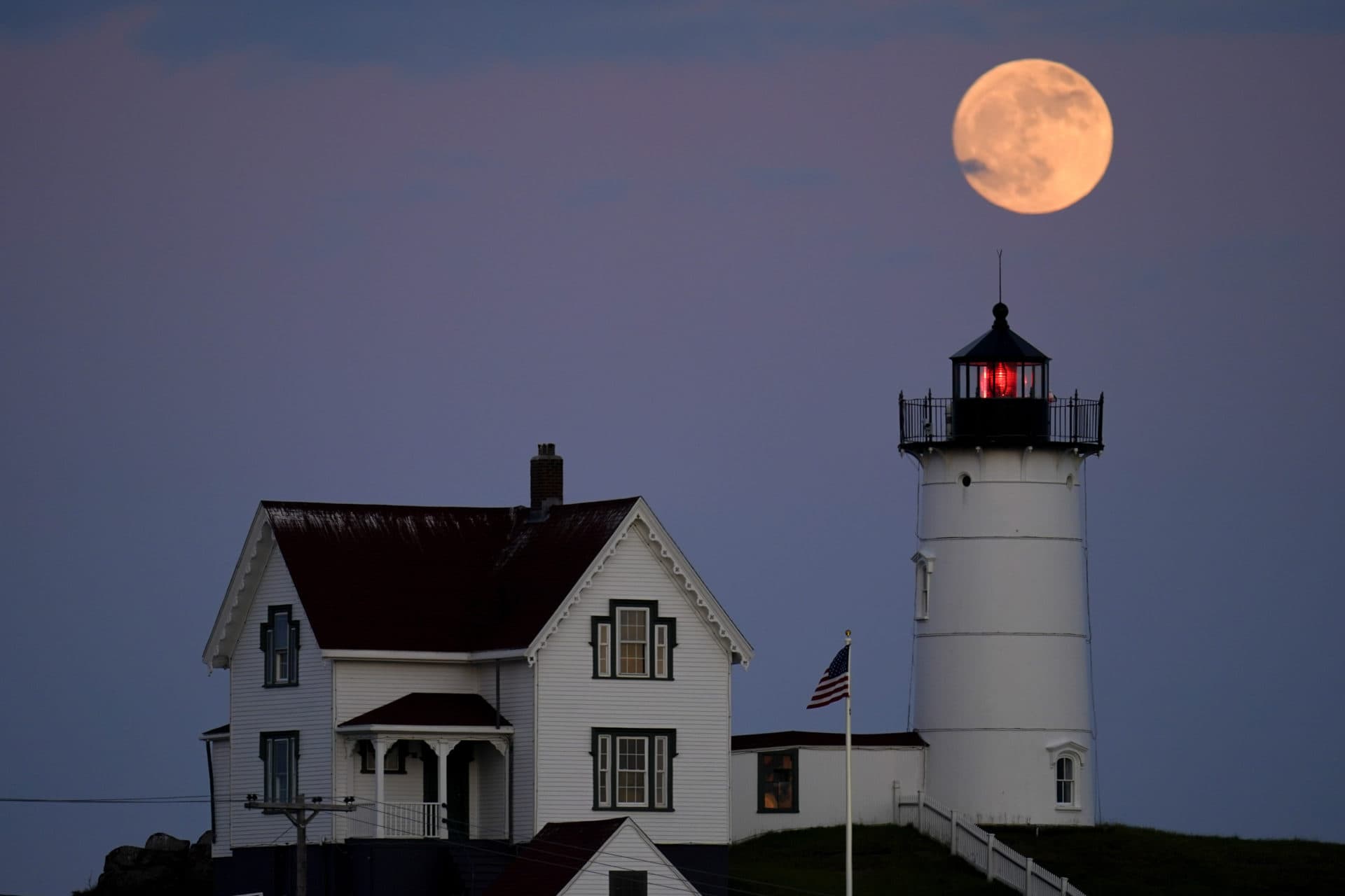 A waxing gibbous moon is seen at 98% percent full as it rises near the Nubble Light, Monday, June 13, 2022, in York, Maine. (Julio Cortez/AP)