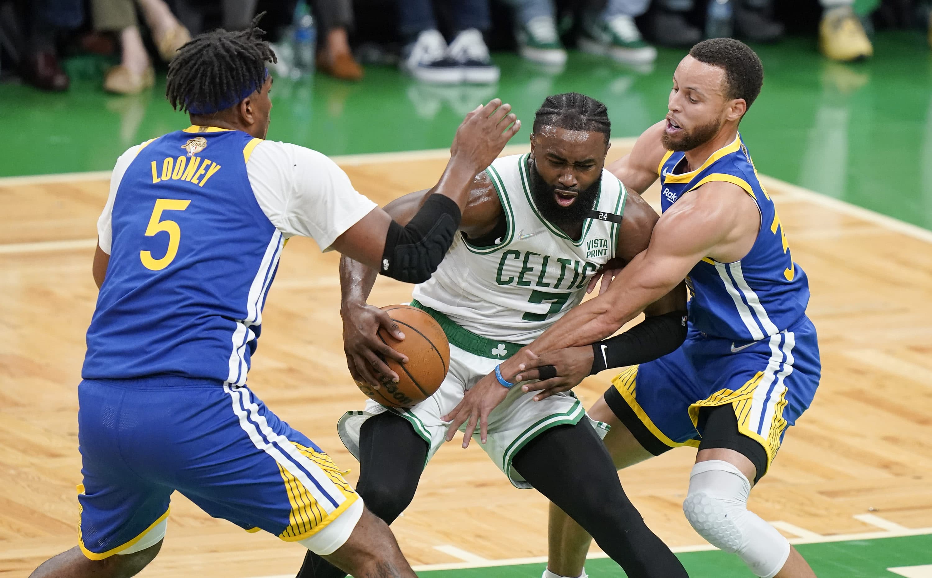 Boston Celtics guard Jaylen Brown (7) drives against Golden State Warriors guard Stephen Curry (30) and center Kevon Looney (5) during the first quarter of Game 6 of basketball's NBA Finals, Thursday, June 16, 2022, in Boston. (Steven Senne/AP)