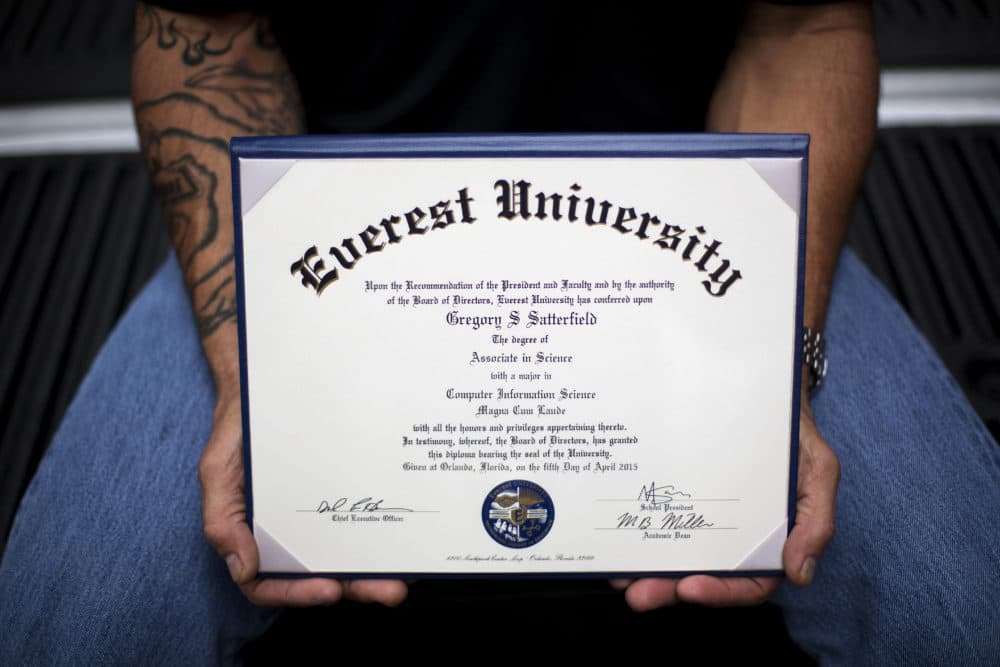 A man holds up a degree from an institution owned by Corinthian Colleges. (David Goldman/AP)