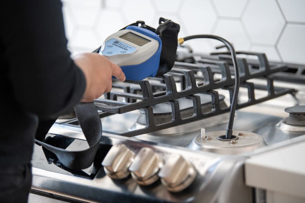 A researcher takes a gas sample from a stove. (Courtesy of Brett Tyron)