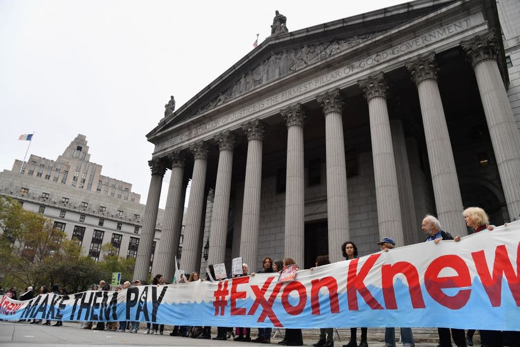 Climate activists protest on the fist day of the ExxonMobil trial outside the New York State Supreme Court building on October 22, 2019 in New York City. (Photo by Angela Weiss/AFP via Getty Images)