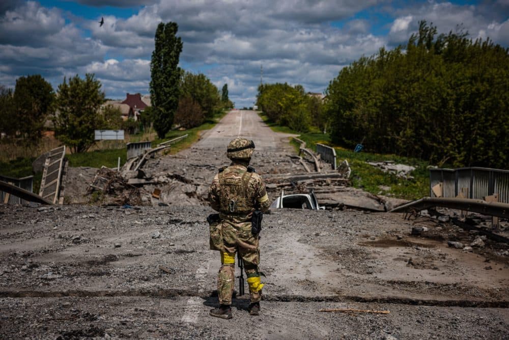 A soldier of the Kraken Ukrainian special forces unit observes the area at a destroyed bridge on the road near the village of Rus'ka Lozova, north of Kharkiv, on May 16, 2022. (Dimitar Dilkoff/AFP via Getty Images)