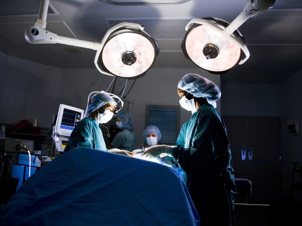 Female nurse and surgeon in scrubs during surgery (Getty Images)