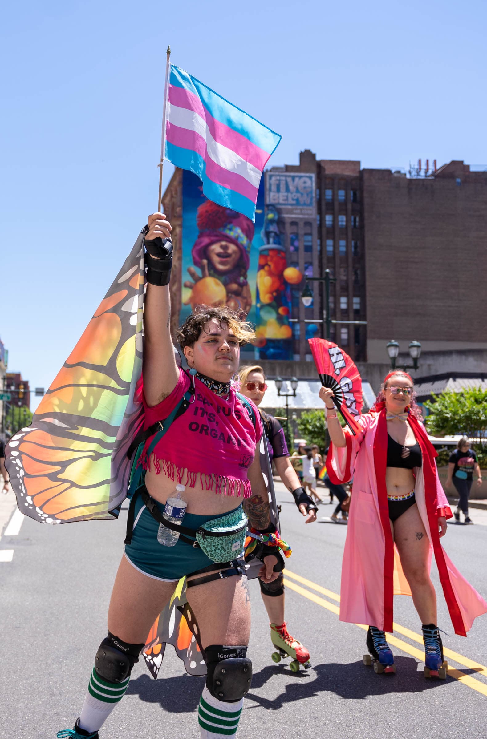 A participant of the 2022 Philly Pride March waves the transgender flag as they follow along the route. (Nathan Morris/Billy Penn)