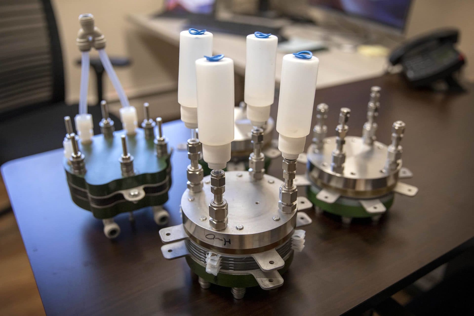 A group of small-development scale electrolyzer stacks on a table at Giner Labs in Concord. (Robin Lubbock/WBUR)