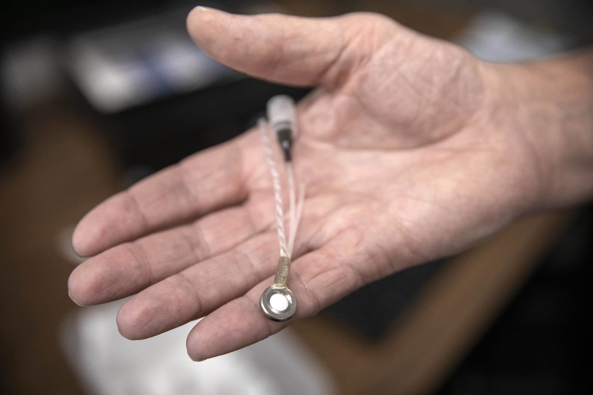 Andy Belt, CEO of Giner Labs, holds a miniature implantable electrolyzer designed to operate under a patient's skin. (Robin Lubbock/WBUR)