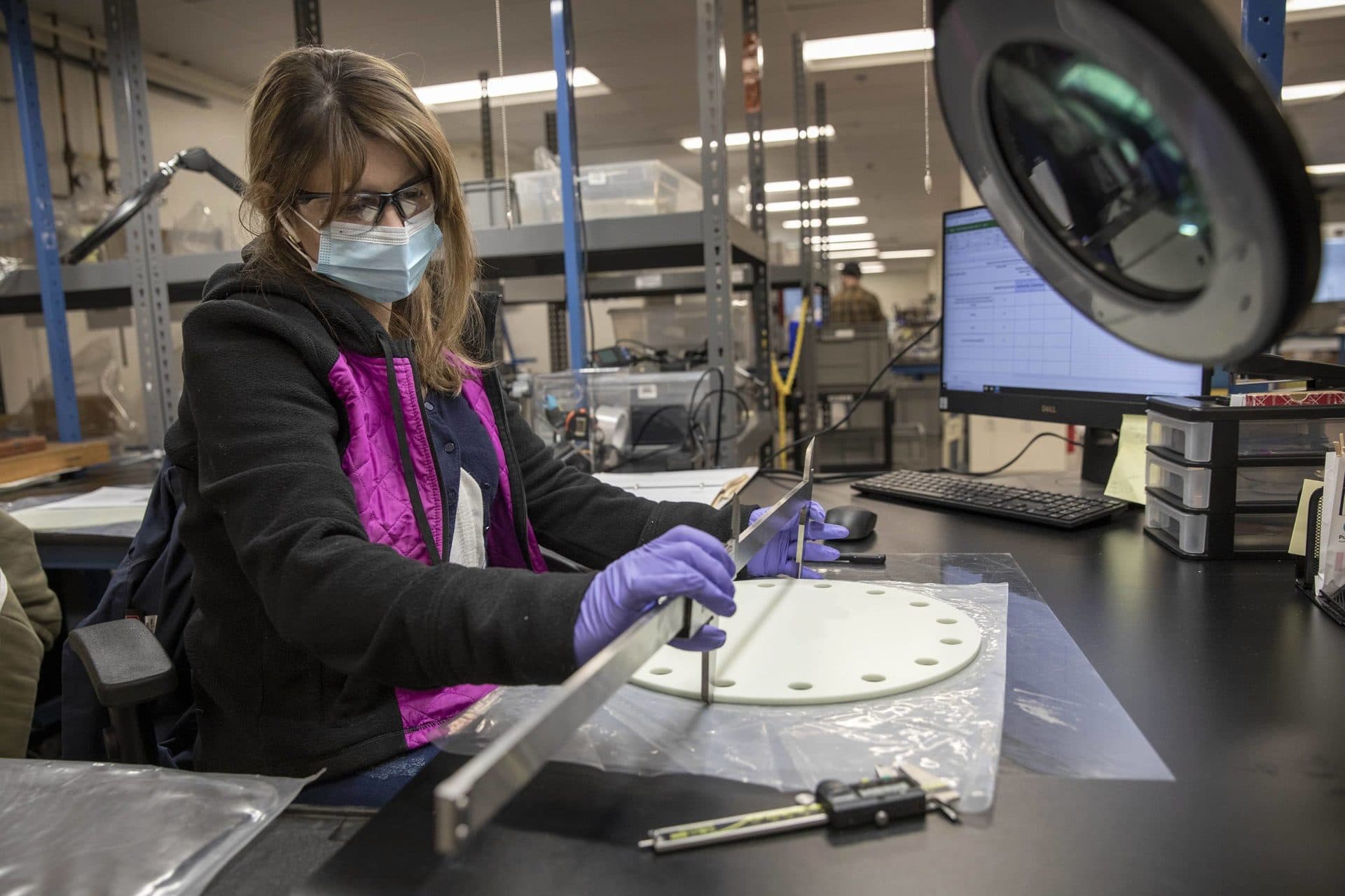 Iris Olvera, a quality controller at Plug Power, checks an insulator from a Merrimack electrolyzer stack. (Robin Lubbock/WBUR)