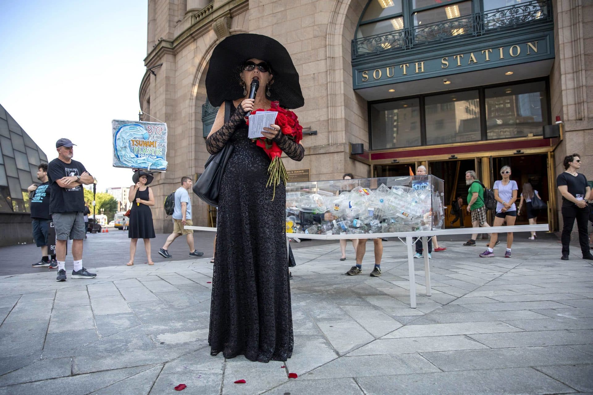 Artist Anne-Katrin Spiess reads a eulogy at a performance of &quot;Death by Plastic&quot; at the entrance of South Station. (Robin Lubbock/WBUR)