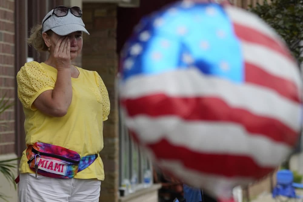 A woman wipes tears after a mass shooting at the Highland Park Fourth of July parade in Highland Park, Ill., a Chicago suburb. (Nam Y. Huh/AP)