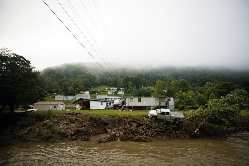 A truck sits on the edge over a river in Whitewood, Va., after being swept away in a flash flood. (Michael Clubb/AP)