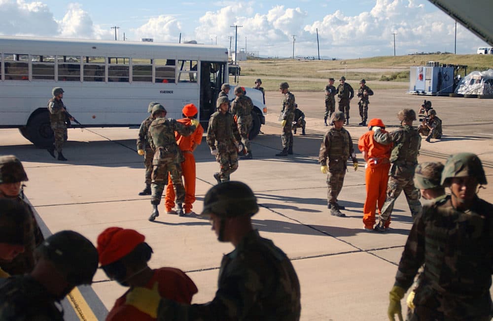 Marines working in pairs taking custody of the first 20 prisoners who were brought to Guantnamo Bay from Afghanistan by way of Incirlik, Turkey. (Staff Sgt. Jeremy Lock/Air Force, via The New York Times)
