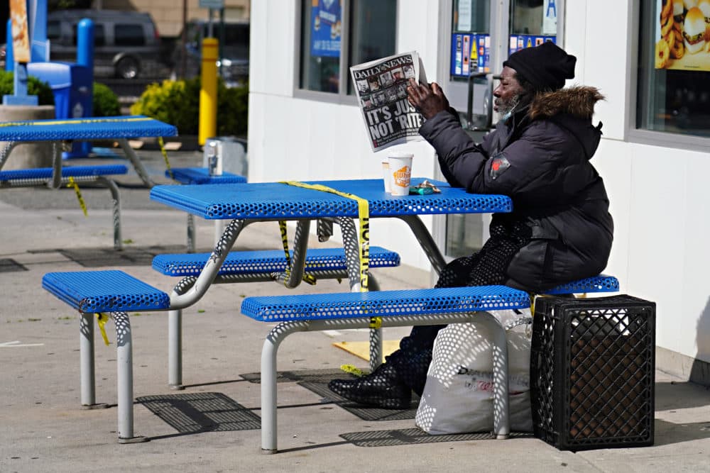 NEW YORK, NEW YORK - MAY 25: A man reads a newspaper at a table outside White Castle in Sunnyside, Queens during the coronavirus pandemic on May 25, 2020 in New York City. Government guidelines encourage wearing a mask in public with strong social distancing in effect as all 50 states in the USA have begun a gradual process to slowly reopen after weeks of stay-at-home measures to slow the spread of COVID-19. (Cindy Ord/Getty Images)