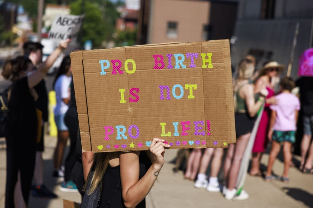 An abortion-rights demonstrator holds a placard during a protest before the Fourth of July parade in Bloomington, Indiana. More than 100 abortion-rights activists participated in a protest march after the Supreme Court of the United States struck down Roe v. Wade on June 24, which will allow states like Indiana to fully criminalize abortion. (Jeremy Hogan/SOPA Images/LightRocket via Getty Images)