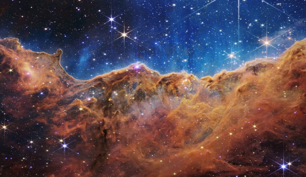 IN SPACE - JULY 12: In this handout photo provided by NASA, a landscape of mountains and valleys speckled with glittering stars is actually the edge of a nearby, young, star-forming region called NGC 3324 in the Carina Nebula, on July 12, 2022 in space. Captured in infrared light by NASA's new James Webb Space Telescope, this image reveals for the first time previously invisible areas of star birth. (NASA, ESA, CSA, and STScI via Getty Images)