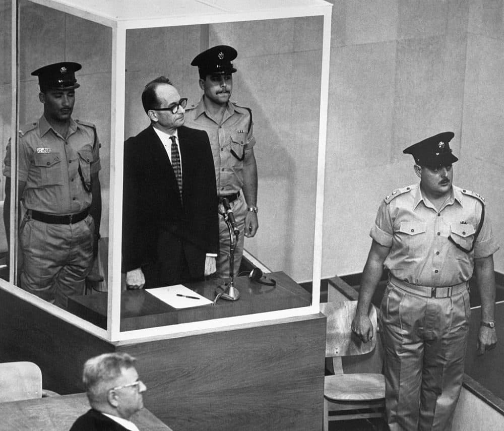 Adolf Eichmann stands in his bullet-proof glass cage in Israel's Supreme Court.