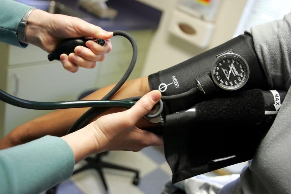 Dr. Elizabeth Maziarka reads a blood pressure gauge during an examination of a patient. (Joe Raedle/Getty Images)