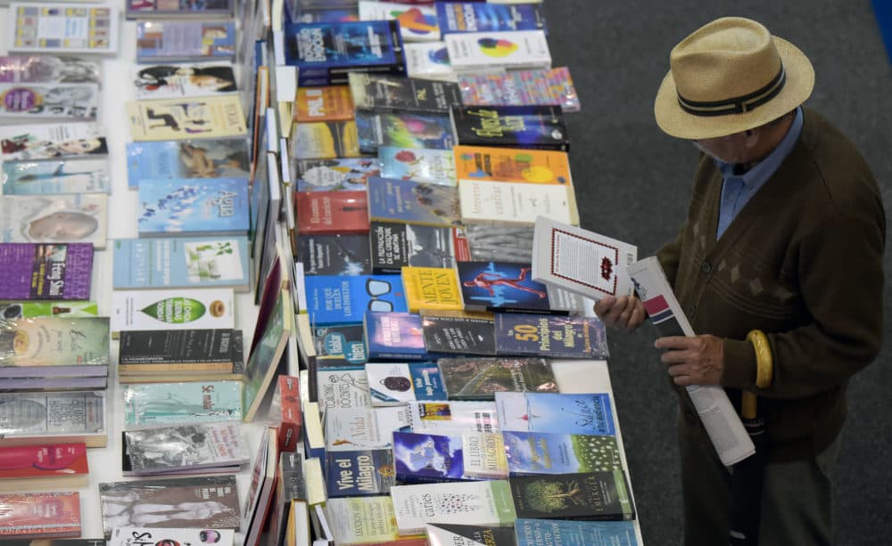 A visitor reads the back cover of a book during the XXXI International Book Fair of Bogota. (Raul Arboleda/AFP via Getty Images)