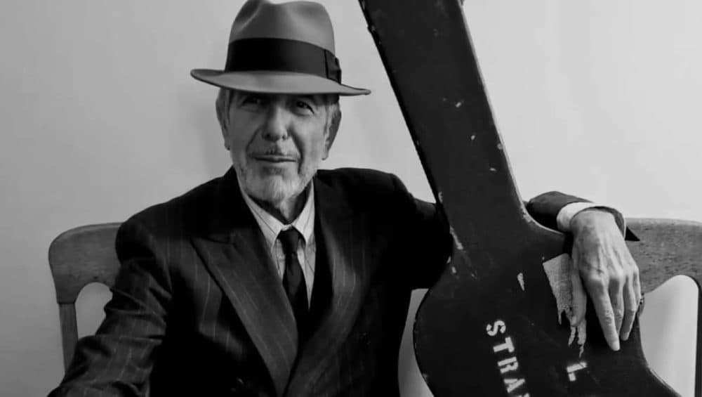 Leonard Cohen holding a guitar case. (Image courtesy of Sony Pictures)