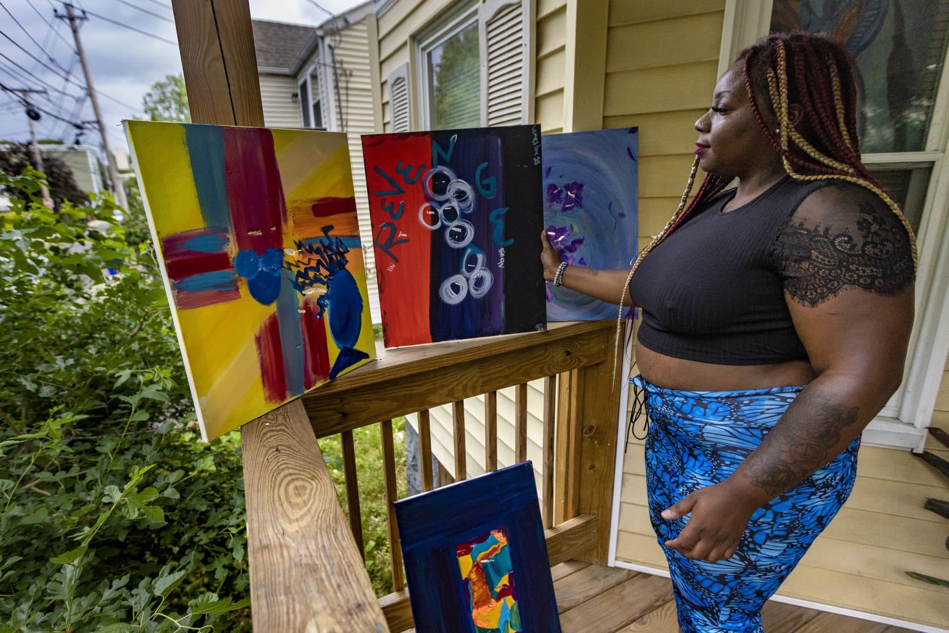 Geneva Davis shows art she made on canvases slashed by her ex-boyfriend. Davis was beaten and held hostage for hours by her ex at her apartment. (Jesse Costa/WBUR)