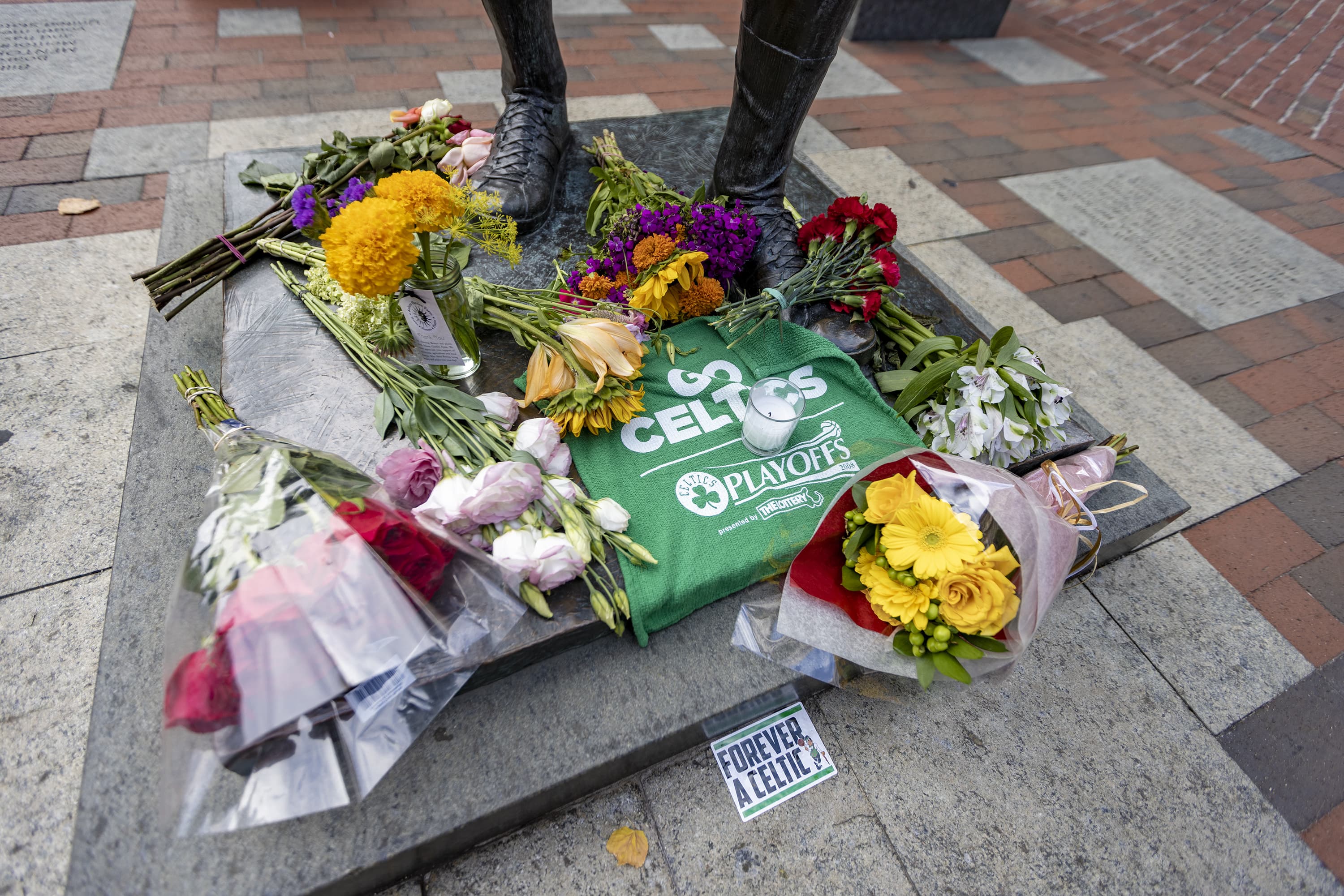 Flowers and tributes at the feet of the Bill Russell statue on Boston's City Hall Plaza. (Jesse Costa/WBUR)