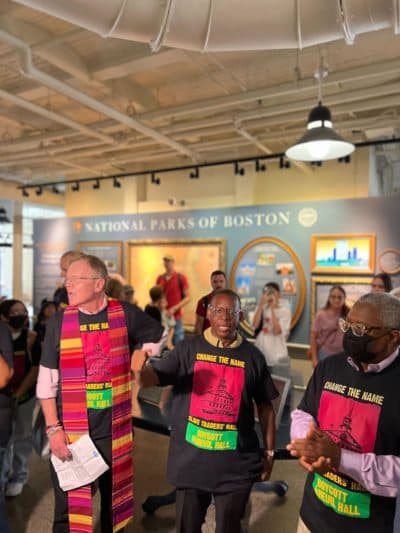 Rev. Kevin Peterson (center) speaks during an event calling attention to changing the name of Faneuil Hall. (Cristela Guerra/WBUR)