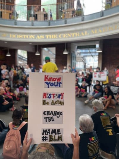 A group of activists stages a sit-in in Quincy Market, part of larger boycott protesting the name of Faneuil Hall. (Cristela Guerra/WBUR)
