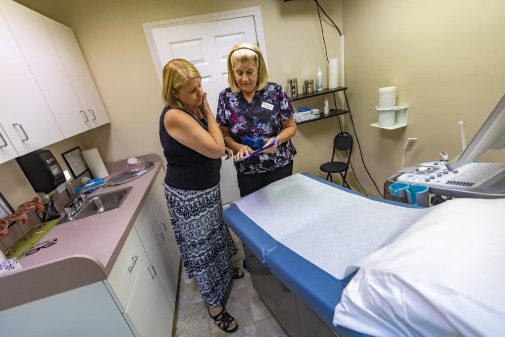 Teresa Larkin, left, and nurse Nancy review a patient chart in the ultrasound room at Your Options Medical in Revere. (Jesse Costa/WBUR)