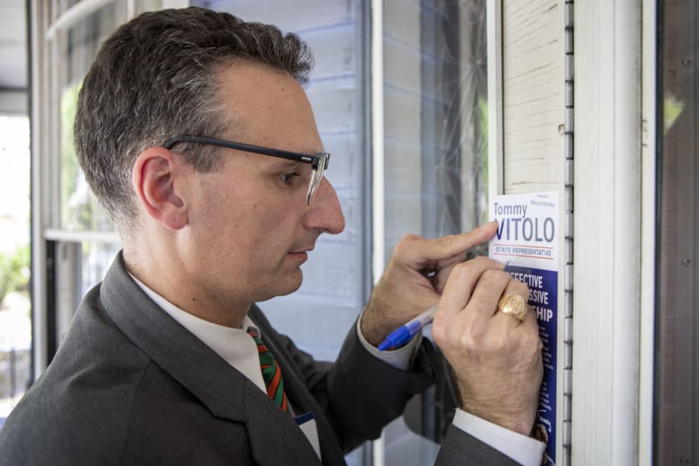 State Rep. Tommy Vitolo, who represents the 15th Norfolk District, leaves a flyer at a house as he campaigns for re-election on a street in Brookline. (Robin Lubbock/WBUR)