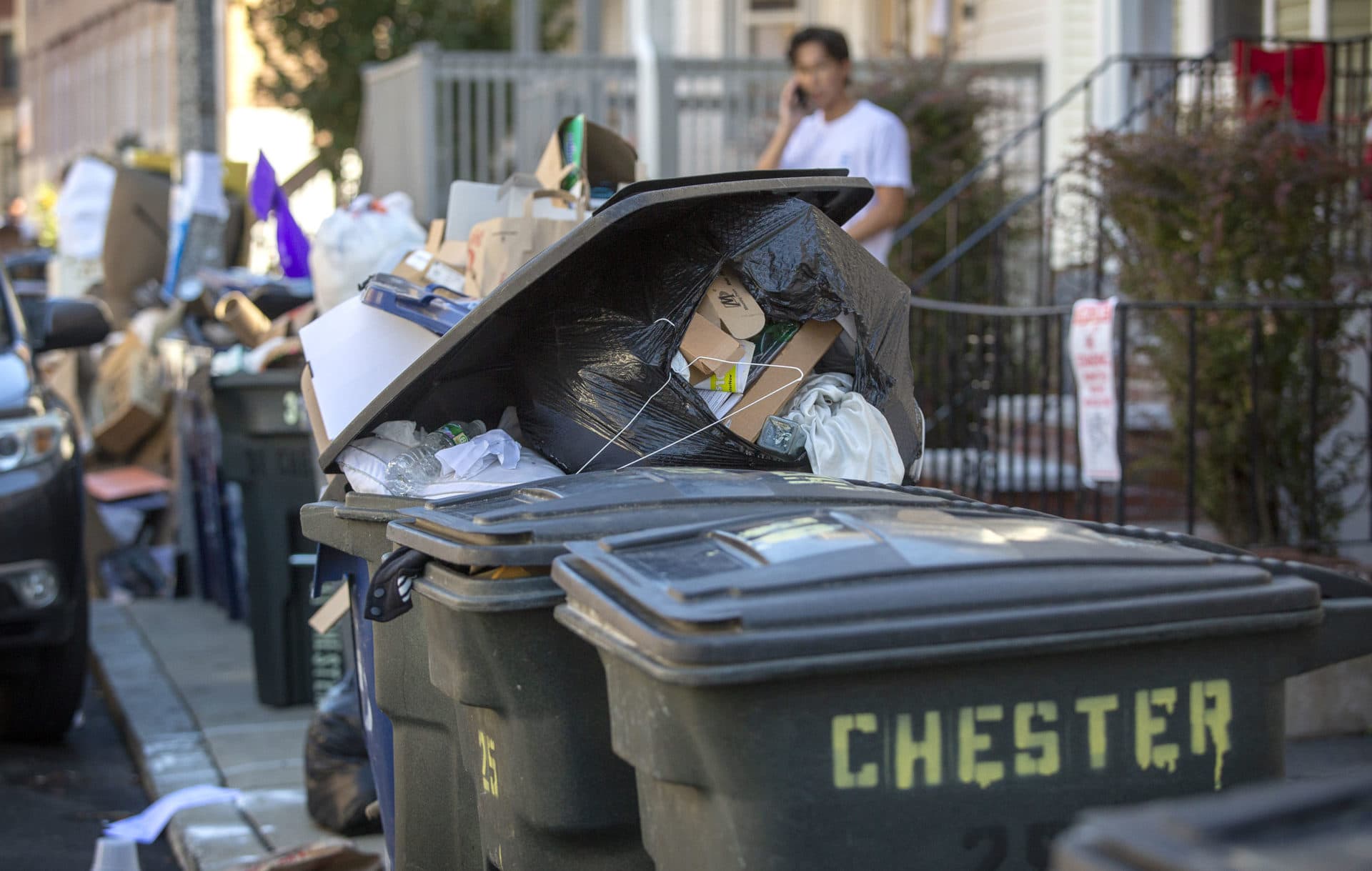 Overflowing garbage cans line Chester St. in Allston on move out day. (Robin Lubbock/WBUR)