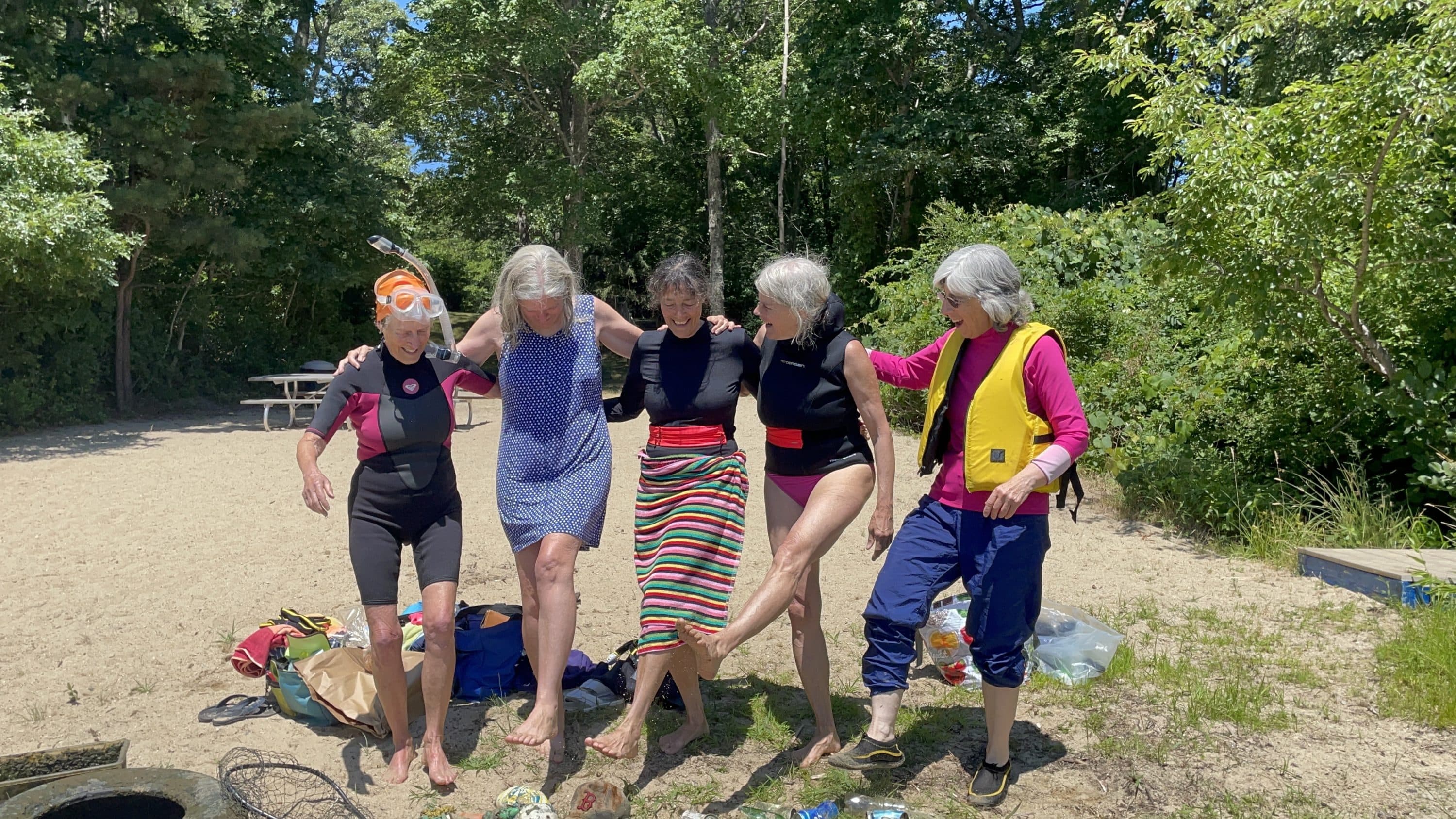 Five members of Old Ladies Against Underwater Garbage form a can-can line, as they wait for their photo to be taken in front of the trash they found. (Layne Fennell)