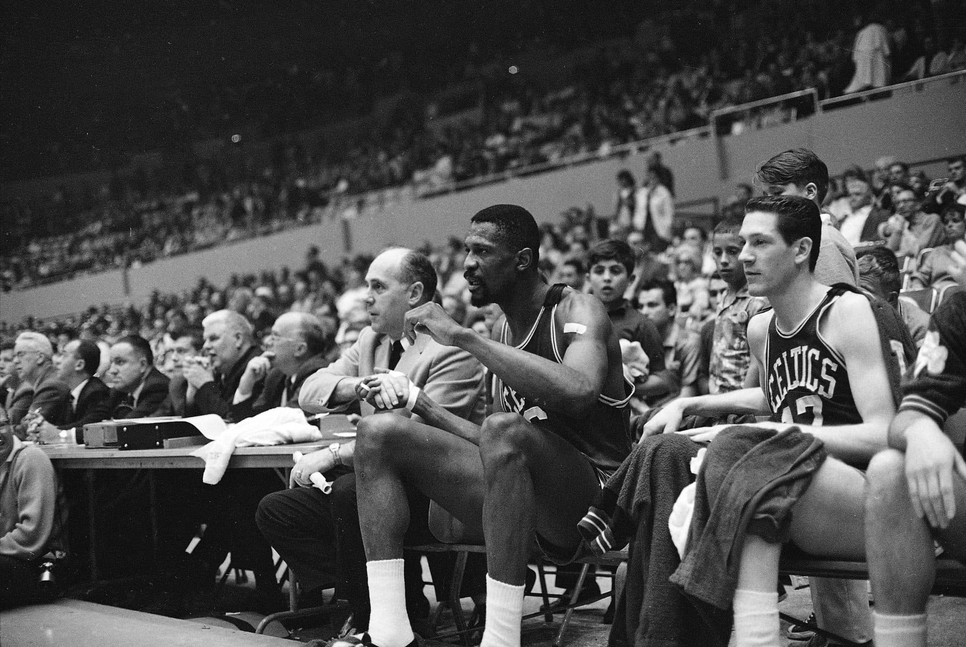 Neither Boston Coach Red Auerbach or center Bill Russell can take his eyes from the action as they shake hands on the bench in the final seconds of the Celtics' 112-99 win over the Lakers in an NBA playoff game at Los Angeles April 23, 1965. Russell had just left the game -- for the first time -- with less than a minute to play. Boston's win gave them a 3-1 lead in the best of 7 series. (Ed Widdis/AP)