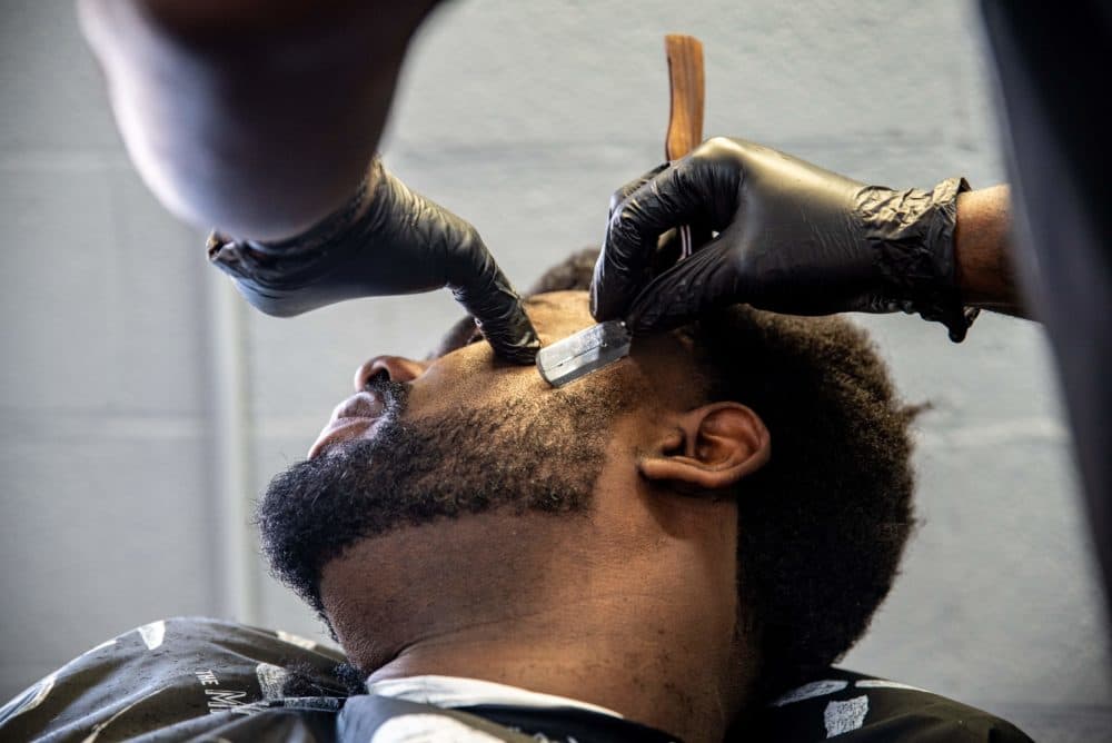 A barber cuts a young man's hair at a barbershop amid the coronavirus pandemic in Austin, Texas on May 8, 2020 following a slow reopening of the Texas economy. (Sergio Flores/AFP via Getty Images)