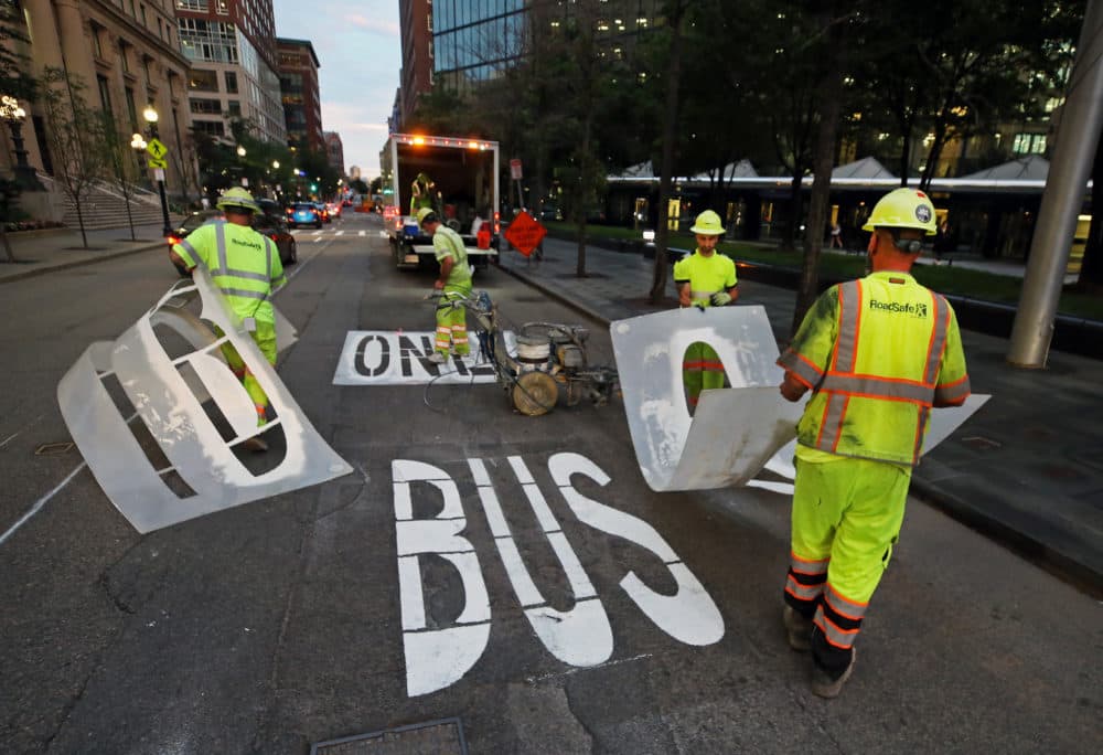 Workers from RoadSafe Traffic Systems are pictured as they paint &quot;Bus Only&quot; on a lane on Clarendon Street in Copley Square in advance of the closing of the MBTA's Orange Line. (Jim Davis/The Boston Globe via Getty Images)