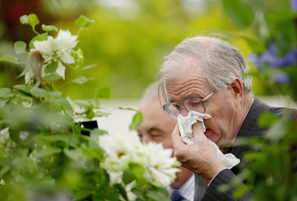 A man covers his face while sneezing (Jim Watson/AFP via Getty Images)