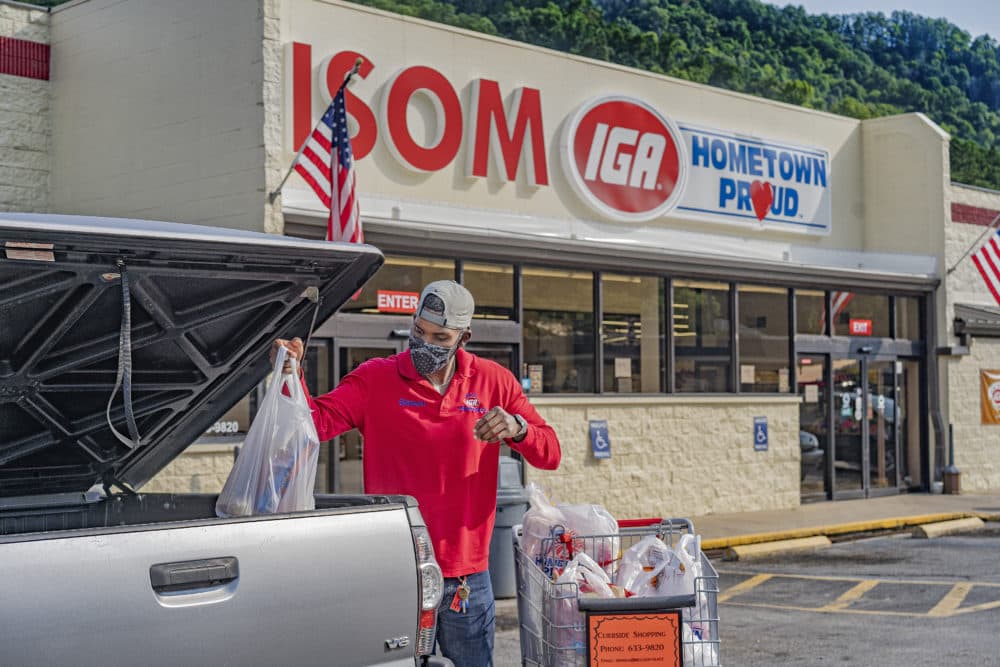 Simon Christon loading groceries into a car in front of Isom IGA. (Mountain Association)
